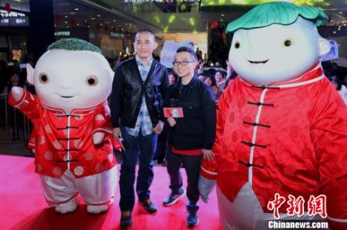 《捉妖记2》主演梁朝伟、导演许诚毅与粉丝们合影。 泱波 摄