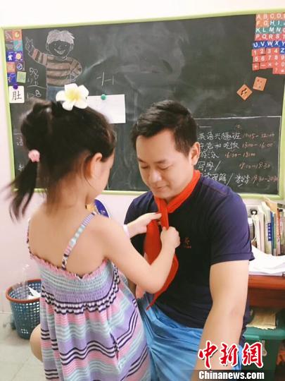 女儿为爸爸系上红领巾 邹前俊 摄