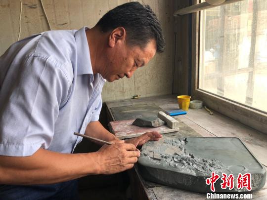 图为卓尼县民间制砚艺人王玉明正在专心雕刻。 徐雪 摄