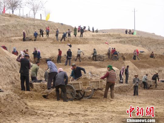 2000年,定西市安定区拉开退耕还林工程的序幕,加快全区生态环境建设。图为民众齐心协力打造梯田。(资料图) 钟欣 摄