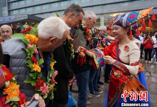 10月9日,身着民族服饰的桂林舞蹈演员为德国老爷车队嘉宾赠送绣球。 欧惠兰 摄