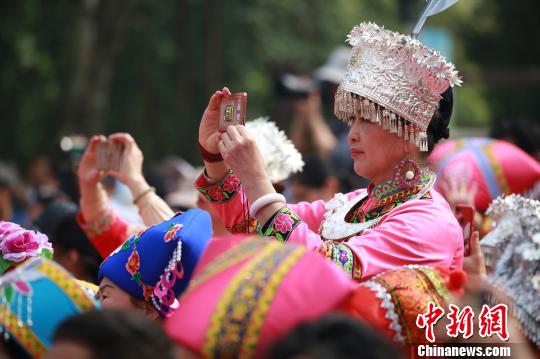 穿着少数民族服饰的观众,用手机记录。 朱柳融 摄
