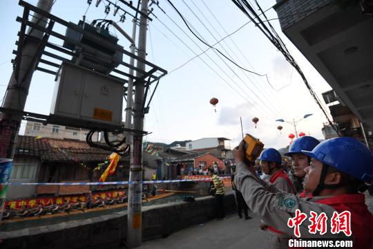 图为国网福州供电公司工作人员在福州市长乐区三溪村,对该村龙舟赛河道两旁的供电线路及设备进行全面巡视,及早消除用电隐患,确保当晚赛事期间的安全可靠用电。 供图 摄