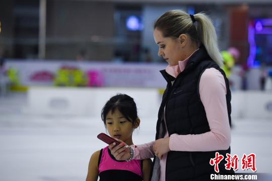 图为祝小雅与俄罗斯教练用翻译器交流。 韩璐 摄