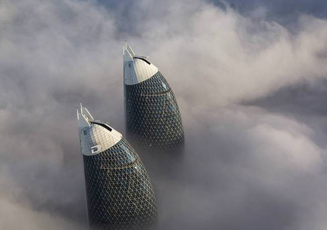 据英国《每日邮报》1月16日报道，近日，一名在阿联酋迪拜住了28年的印度籍商人拉斯特姆•阿兹米（Rustam Azmi），在迪拜一幢摩天大楼的高层里拍下了一组浓雾中高楼耸立、直穿云霄的罕见照片。