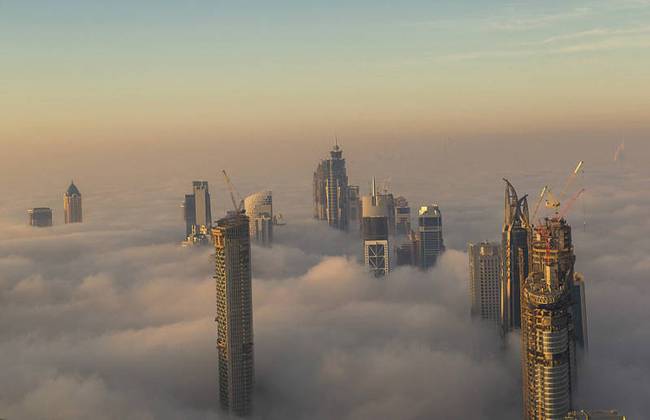 据英国《每日邮报》1月16日报道，近日，一名在阿联酋迪拜住了28年的印度籍商人拉斯特姆•阿兹米（Rustam Azmi），在迪拜一幢摩天大楼的高层里拍下了一组浓雾中高楼耸立、直穿云霄的罕见照片。