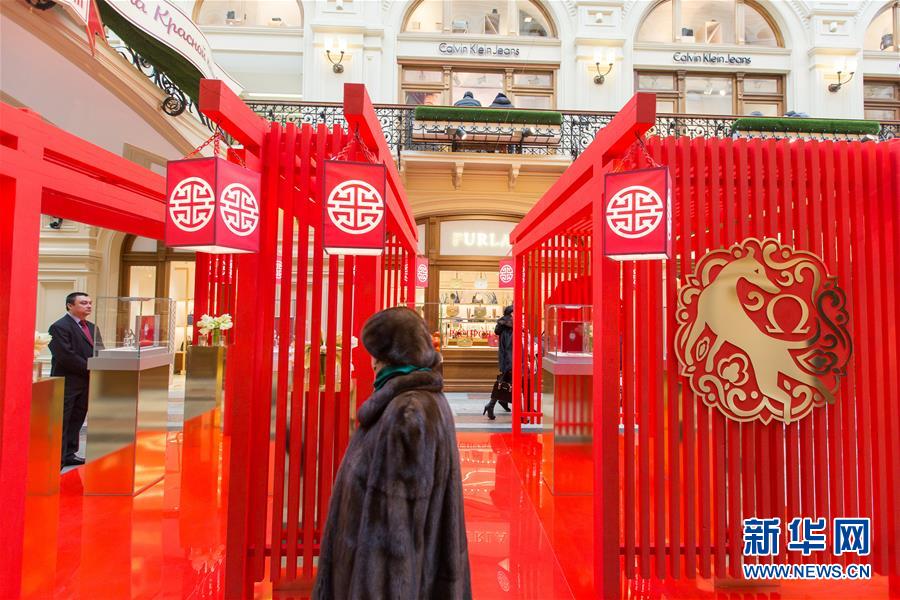 2月8日，在俄罗斯首都莫斯科古姆商场，顾客走过结合中国元素设计的柜台。