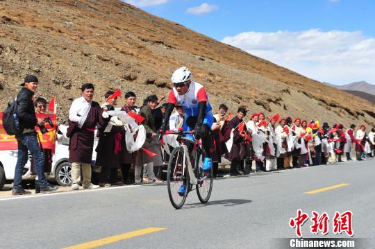 图为17日,在“2018首届跨喜马拉雅自行车极限赛”第二赛段的比赛中,当地各族民众在终点米拉山口附近为参赛车手加油助威。 张伟 摄