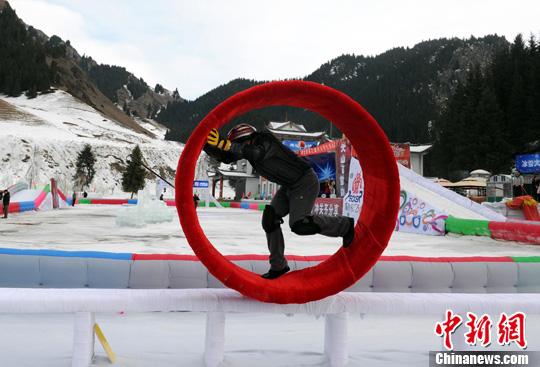 资料图:12月29日,乌鲁木齐第九届丝绸之路冰雪风情节,亮点“冰雪大冲关”,在天山大峡谷景区如期举行。图为一位市民正在挑战冰上风火轮关卡。<a target='_blank' data-cke-saved-href='http://www.chinanews.com/' href='http://www.chinanews.com/'><p align=