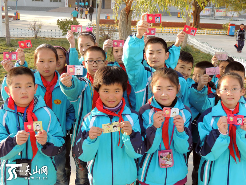 11月3日,博湖县第一小学学生们争先展示印有校徽的新校卡。