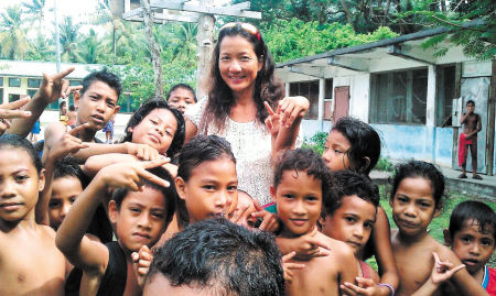 万金玉在太平洋的一个小岛上与孩子们快乐合影。